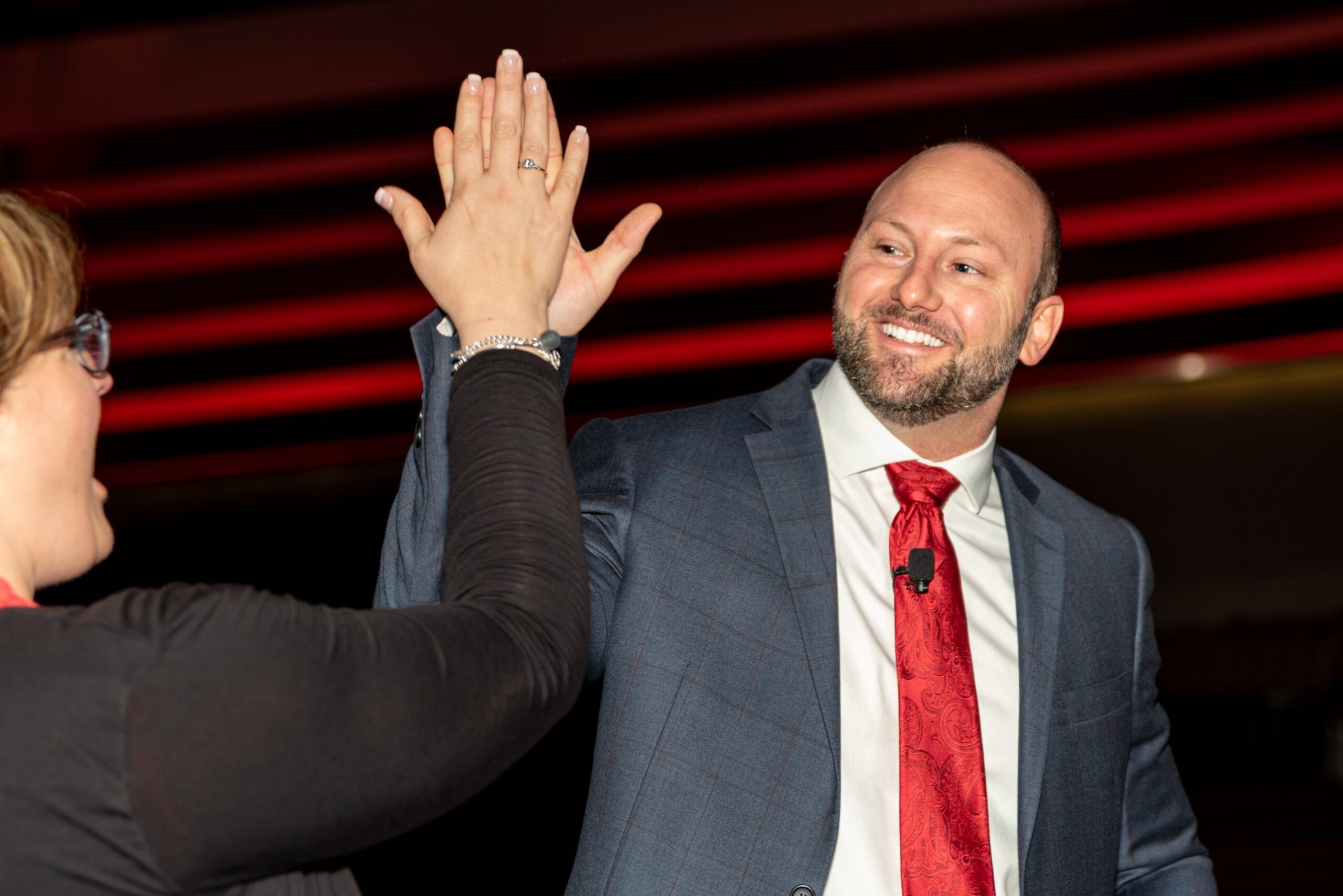 Eric Papp high-fiving an audience member on stage
